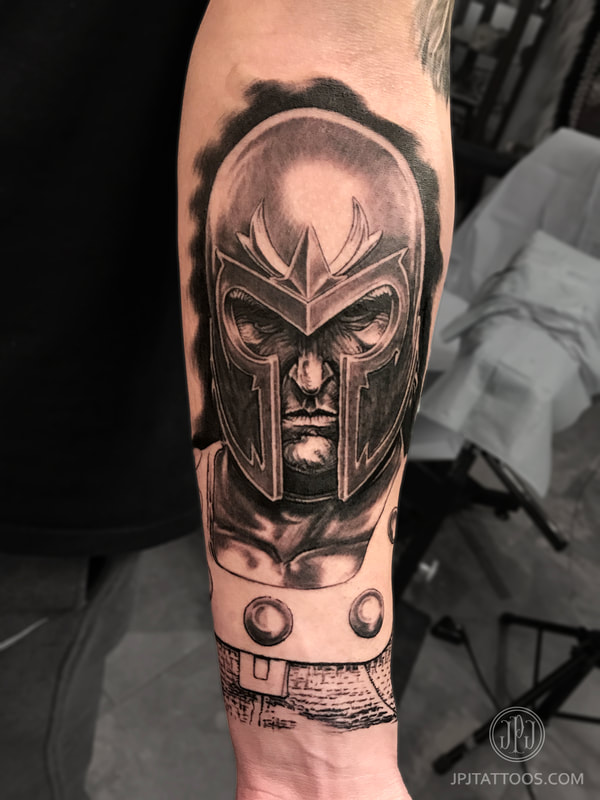 Magneto Tattoo arm foreground focus photo.